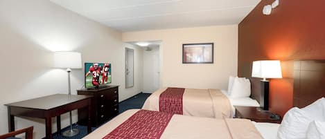 Quarto de hotel com duas camas, uma escrivaninha, uma cadeira, uma televisão, um espelho e uma porta que dá para outro quarto.