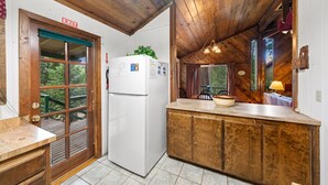 A kitchen with a wooden ceiling, a white refrigerator, a wooden counter, and a view of the outdoors. - Secluded Cozy Cottage: Walk to Town, Private (Idyllwild)