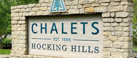 A stone sign with the name 'CHALETS' and 'HOCKING HILLS' along with the establishment year 'EST. 1988'.