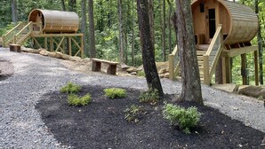 Two wooden treehouses with external staircases, surrounded by a forest. - Fireside Lodge - Hosted by The Chalets (Logan)