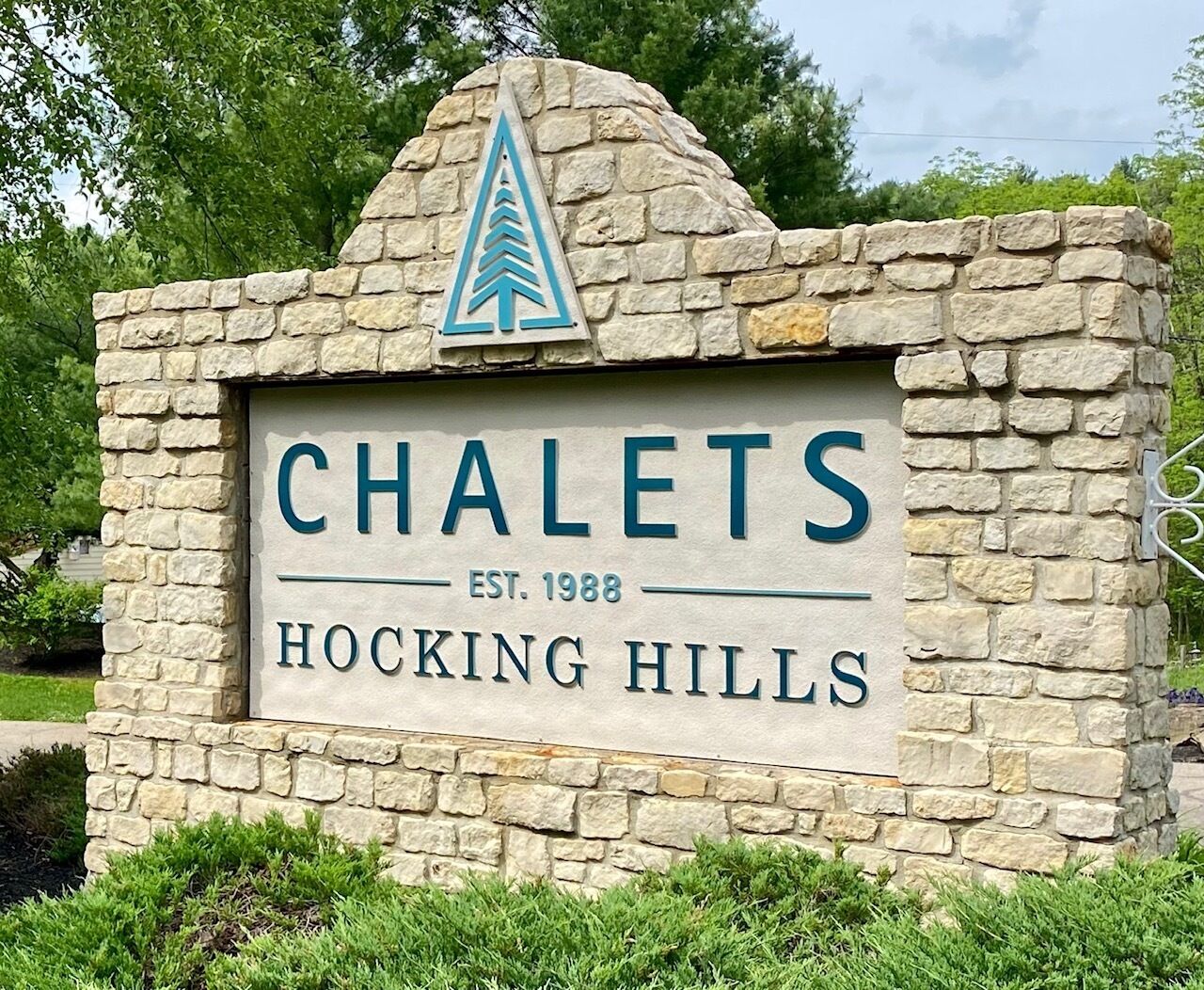 A stone sign with the name 'CHALETS' and 'HOCKING HILLS' along with the establishment year 'EST. 1988'.