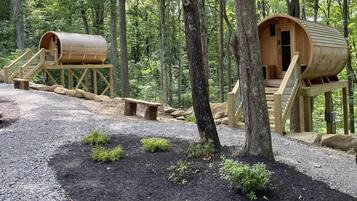 Escape to a secluded cabin nestled in the forest, surrounded by nature and a gravel path.