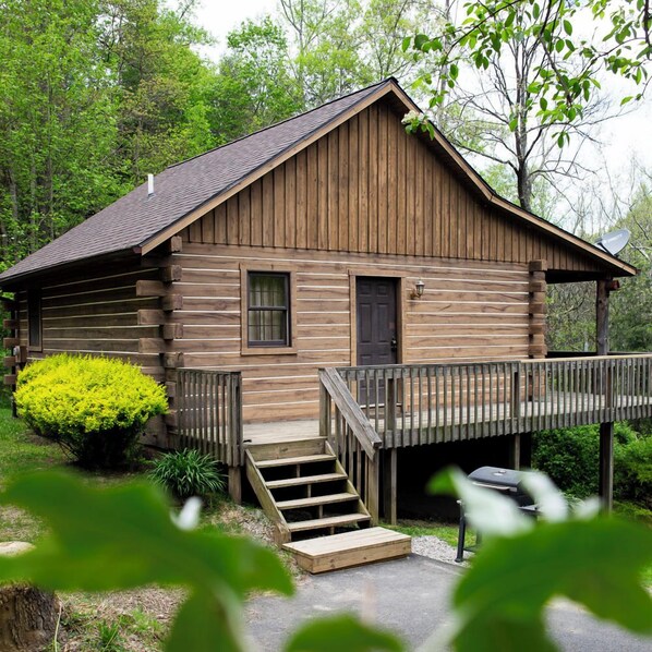 Eine rustikale Holzhütte mit Veranda, kleinem Fenster und einer Tür.