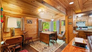 Ein Holzblockhaus-Interieur mit Essbereich, Küche und einer gemütlichen Sitzecke.