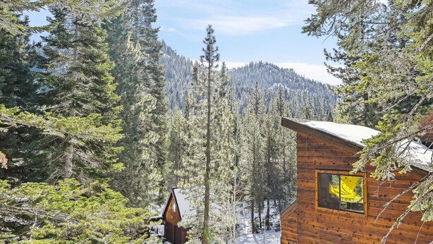 A cabin surrounded by dense forest and snow-covered mountains. - On the Edge at Alpine By Tahoe Getaways - Dog OK- Mountain Views- Ski Shuttle! (Alpine Meadows)