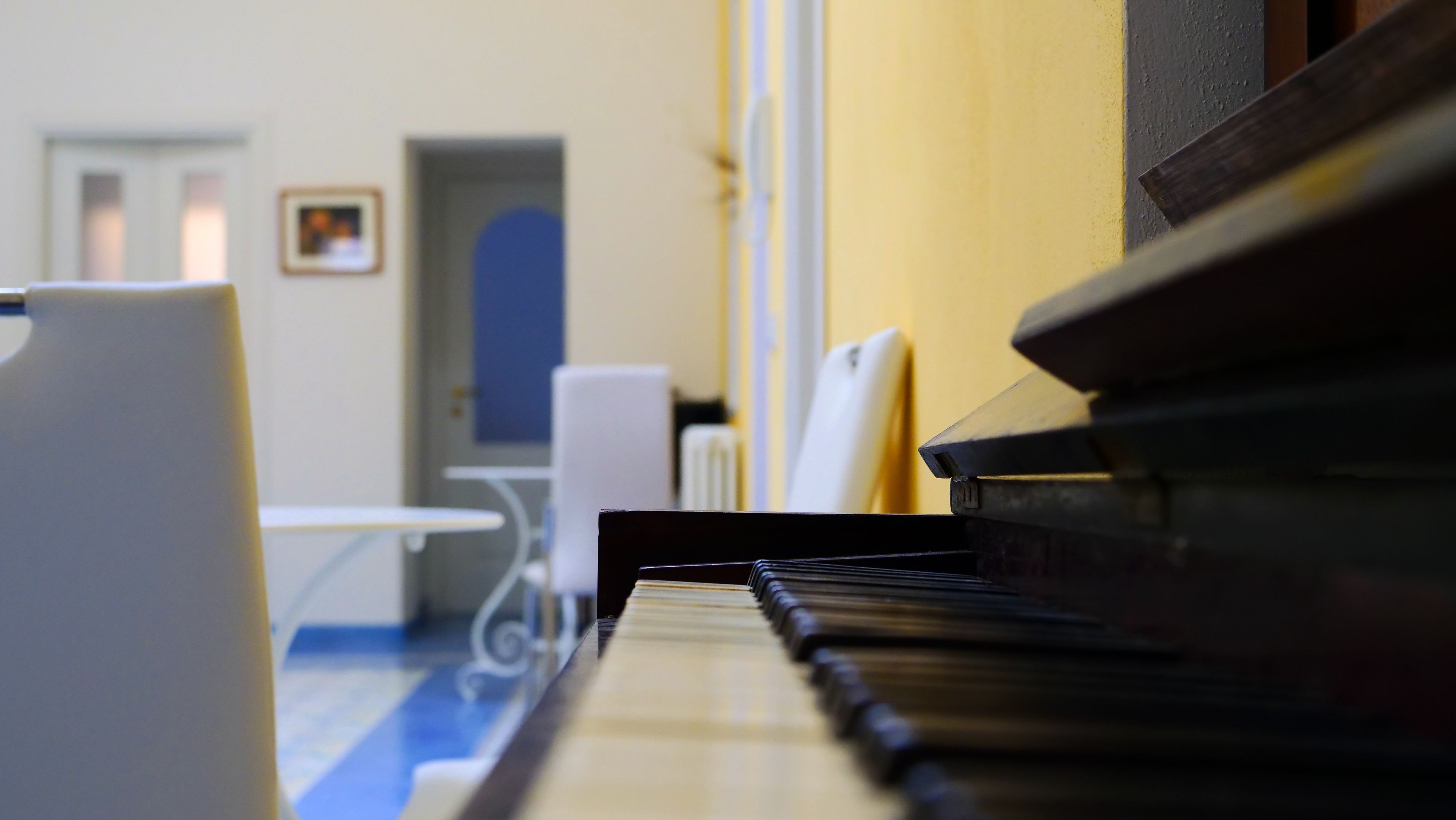 Un piano en una habitación con suelo azul y una mesa blanca.