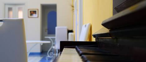 Un piano en una habitación con suelo azul y una mesa blanca.
