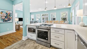 Una cocina moderna con una isla grande, electrodomésticos de acero inoxidable y vista al área de comedor.