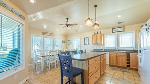 A spacious kitchen with a large island, wooden cabinets, and a ceiling fan. - Shorenuff - Nags Head MP 11, Ocean View, Beach 200 Yds, Pool, Hot Tub, Pool Table, YR Flex Stays (Nags Head)