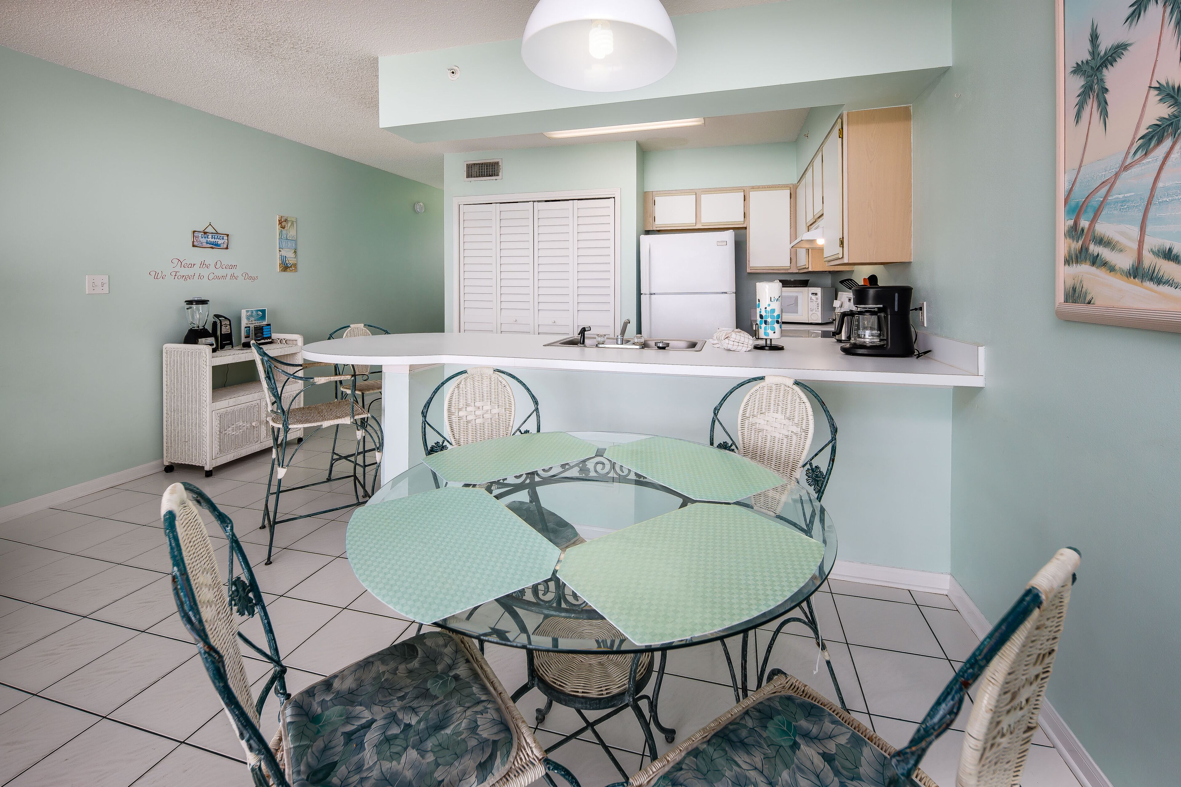 A compact kitchen with a central island, white cabinets, and a microwave.