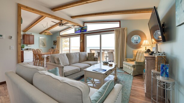 A spacious living room with a sofa, coffee table, and a dining area with chairs and a table.