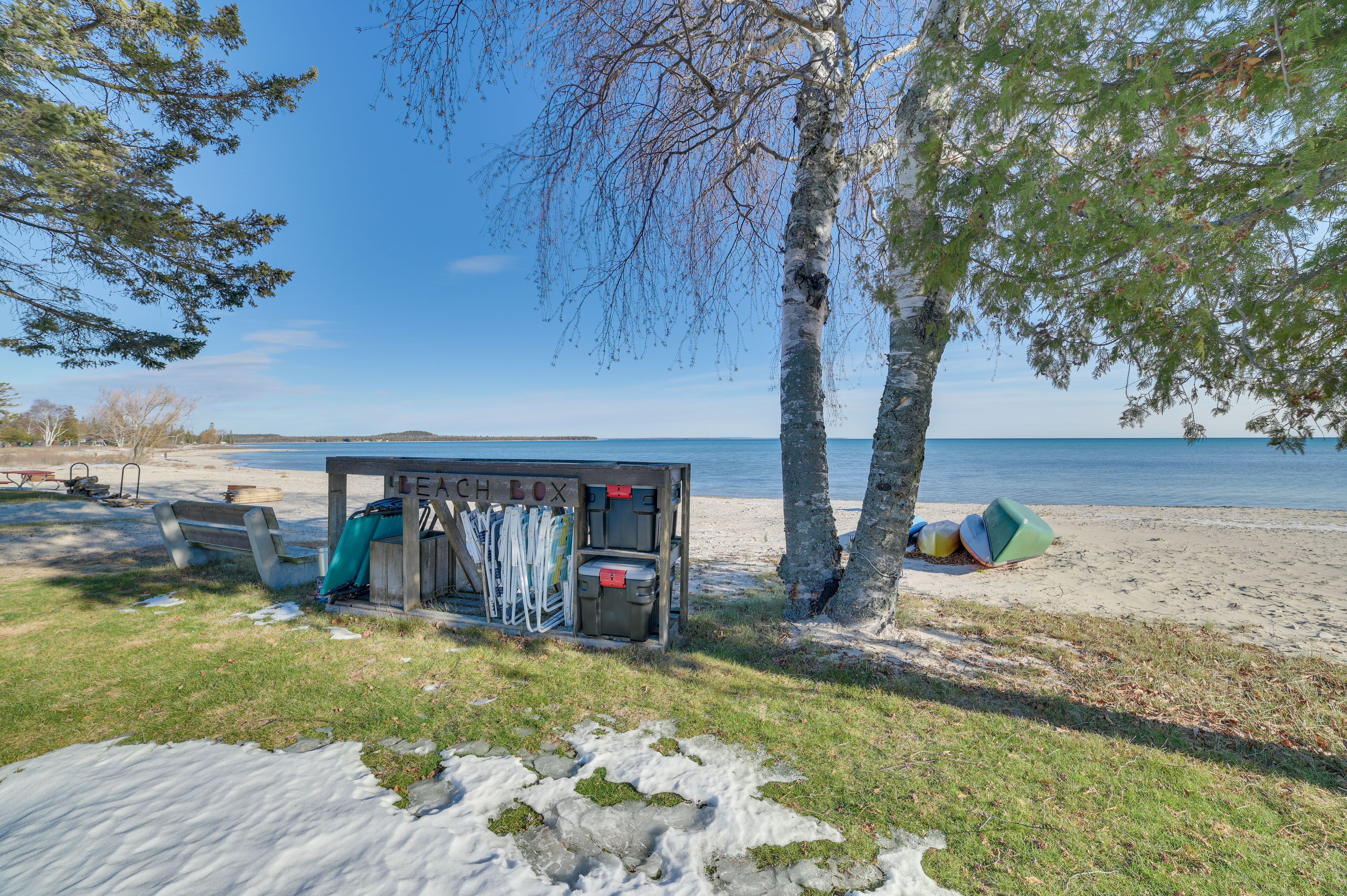 A beachside cabin with a bench, a small table, and a storage unit labeled "LEACH BOX".