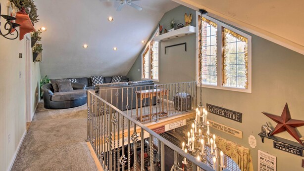 Un espace de vie de style loft avec un plafond haut, un ventilateur de plafond et un escalier menant à un niveau supérieur.