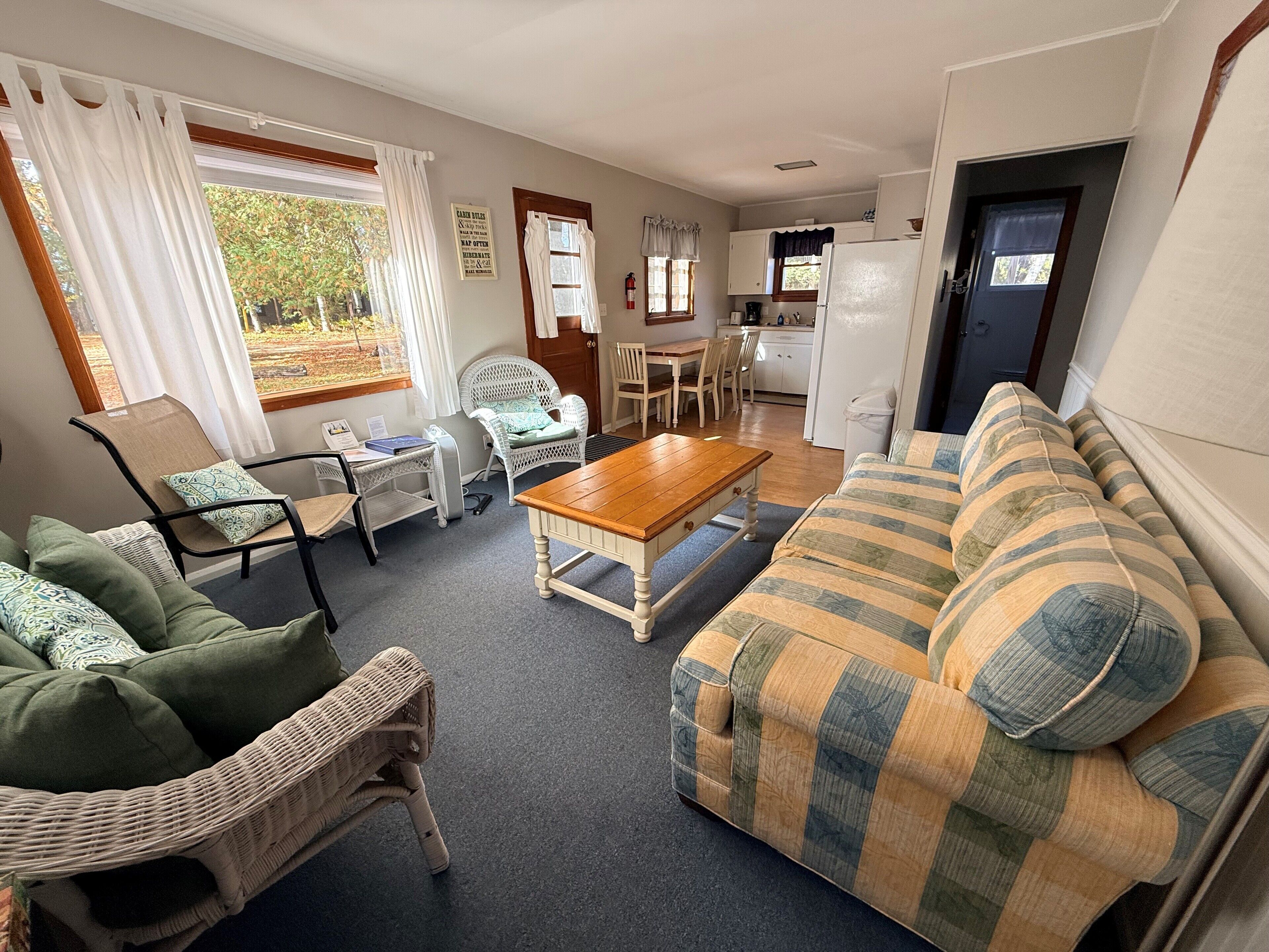 A cozy living room with a sofa, chairs, a coffee table, and a dining area with a table and chairs.