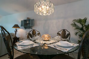 Una mesa de comedor lista con platos, vasos y un centro de mesa con velas.