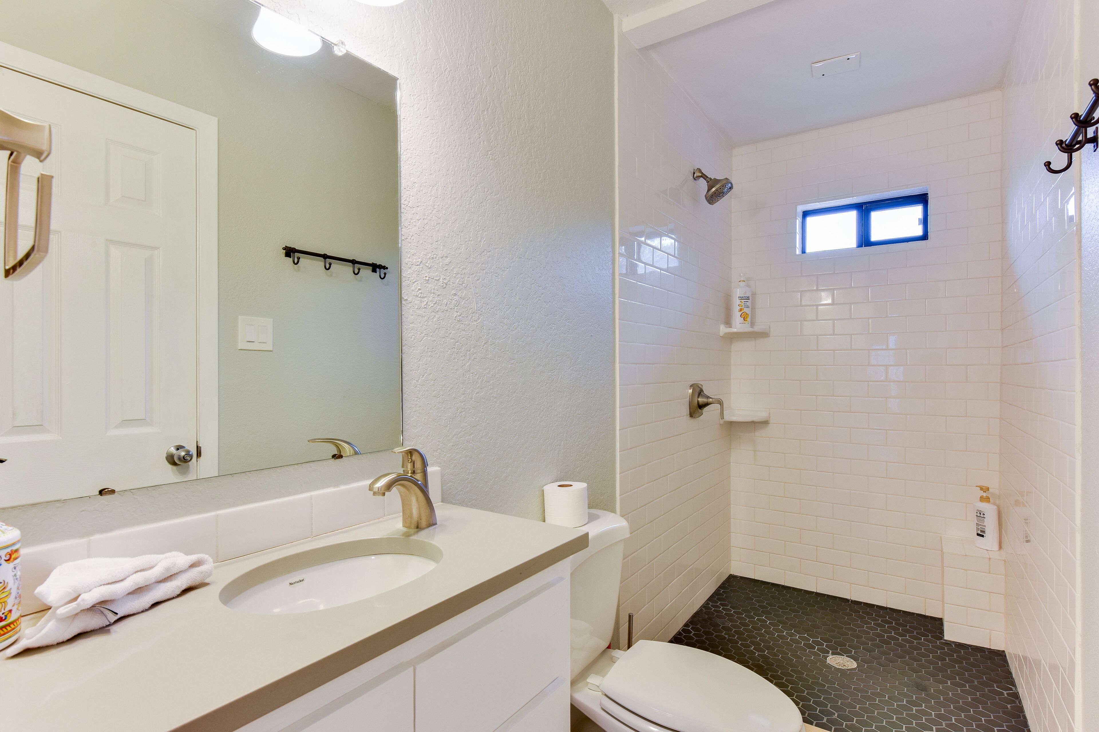 A bathroom with a sink, toilet, and shower.
