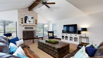 TV connectée, cheminée, table de tennis de table, livres