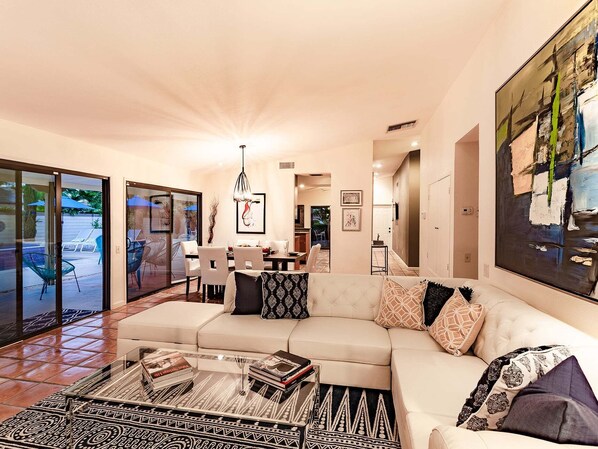 A modern living room with a sofa, coffee table, and artwork.