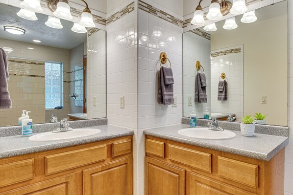 A bathroom with two sinks, wooden cabinets, a mirror, and a window. - 'TroutFest' Riverfront Norfork Home, Great Fishing (Norfork)