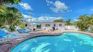 A residential property with a swimming pool, outdoor seating, and a covered patio area. - 4BR Coastal Cottage w/ Heated Private Pool | 1 Block to Bean Point Beach | Dog Friendly *(See Note) ! (Anna Maria)