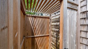 A wooden structure with a slanted roof and a metal gate.