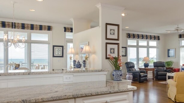 A spacious living area with a large island, a fireplace, and a view of the ocean.