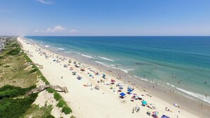 A beach with a wooden boardwalk leading to the shore, sandy beach, and ocean. - The Coast Is Clear - Corolla, Ocean Sands, Oceanfront, 150 Ft to Beach, Open All Year, Pets OK (Corolla)