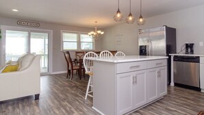 A modern kitchen with a central island, stainless steel appliances, and pendant lighting.