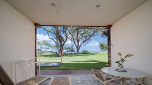 Eine Terrasse mit Tisch und Stühlen, ein kleiner Garten und Meerblick.
