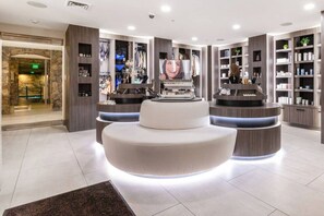 A modern lobby with a central seating area, a reception desk, and a wall with shelves displaying various items. - Westgate 4707 AB (Park City)