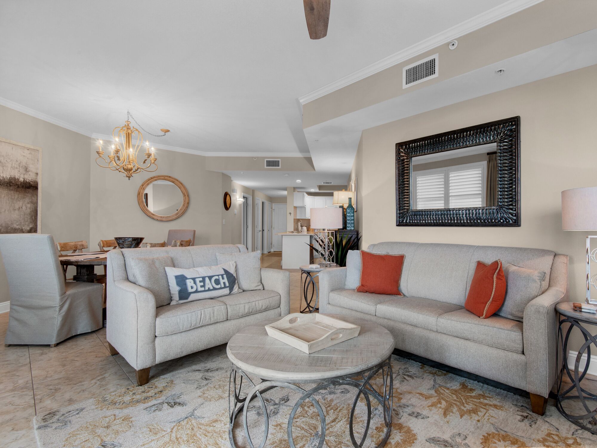 A spacious living room with a fireplace, a chandelier, and a dining area.