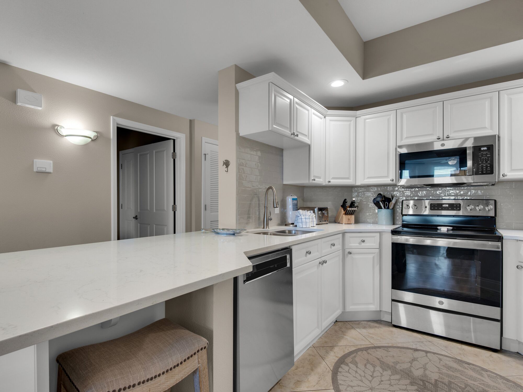 Una cocina moderna con armarios blancos, electrodomésticos de acero inoxidable y una isla grande.
