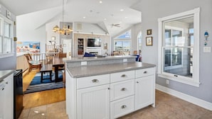 A spacious kitchen with a large island, white cabinetry, and a view to the outside. - V1233- Beautiful! 5 BRs, Private Pool, Hot Tub, Pool Table and Dog Friendly! (Corolla)