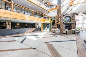A spacious lobby with a high ceiling, a fireplace, and a seating area. - Westgate 4606 (Park City)