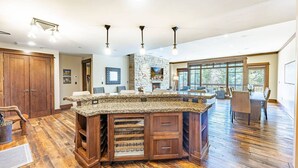 Una cocina amplia con una isla de granito, armarios de madera y una pared decorativa de piedra.
