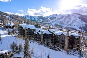 A multi-story hotel with a ski slope in the background.