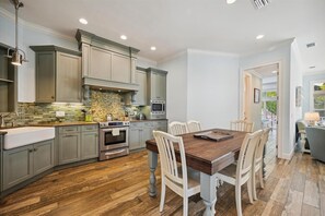Enjoy family meals and gatherings around the large dining table, with a central island for cooking and ample storage in the sleek, modern kitchen.