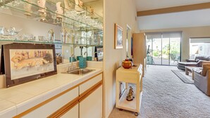 Una cocina moderna con un expositor de vidrio, un lavamanos y una encimera con un cuadro enmarcado.