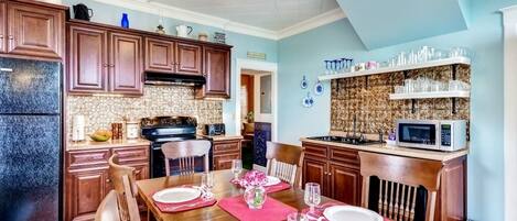 A dining area with a wooden table set for four, equipped with plates, cutlery, and glasses.