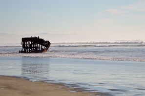 Una playa con una estructura sumergida parcialmente en el agua.