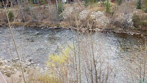 A river with surrounding trees and a wooden cabin in the background. - Creekside Condo in Downtown Frisco with Hot Tub, Pool & Mountain Views! (Frisco)