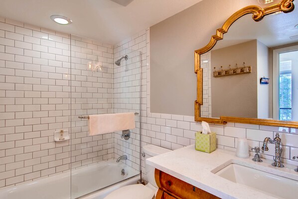 Un bagno moderno con doccia vetrata, lavabo e uno specchio grande.