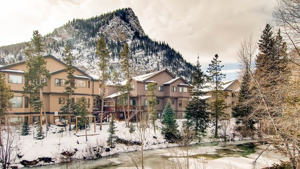A resort with multiple buildings, a snow-covered landscape, and a river. - Creekside Condo in Downtown Frisco with Hot Tub, Pool & Mountain Views! (Frisco)