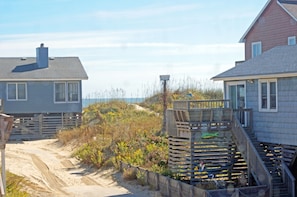 A coastal house with a sandy path leading to it, surrounded by vegetation. - SN8421- Oceanside, 3 BRs W/2 Baths,Direct Beach Access, Wifi, & Pet Friendly! (Nags Head)