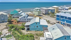 Zona residencial a la costa amb cases, una platja i una vista despejada de l'oceà.
