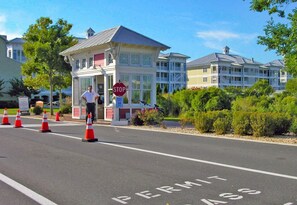 A gated entrance with a stop sign, traffic cones, and a permit sign on the road.