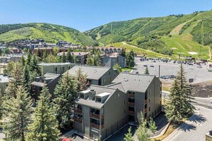 A multi-story hotel with a parking lot in a mountainous area.