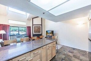 A modern kitchen with a granite countertop, wooden cabinets, and a fireplace.
