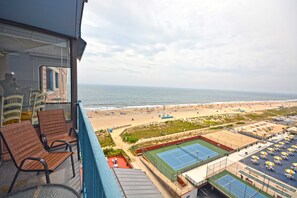 A balcony with a view of the beach and tennis courts.