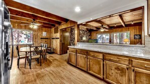 Una cocina con armarios de madera, encimera de granito y un comedor con sillas.